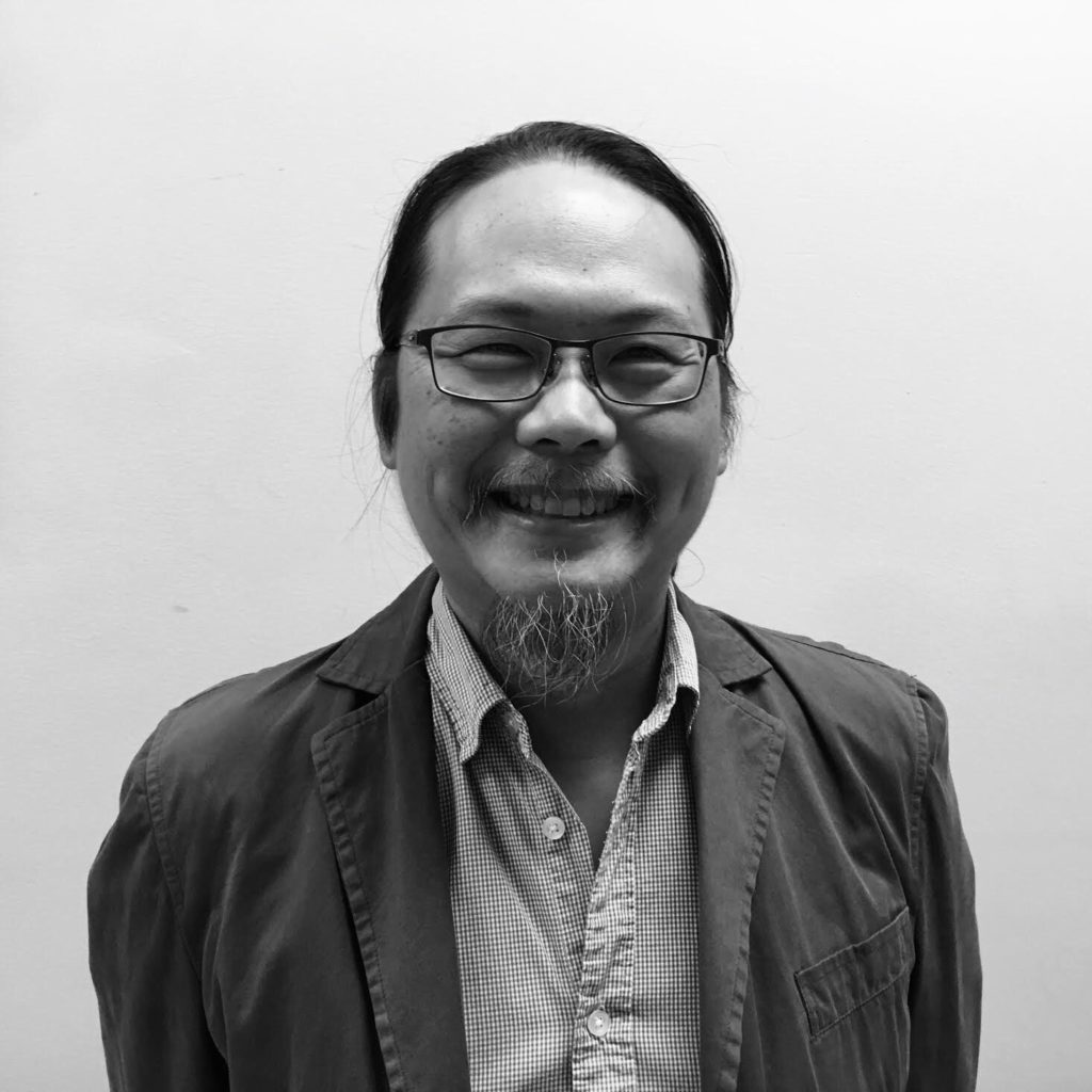 Black and white photograph of Michael C.K. Mah against a white background, from the shoulders up, smiling