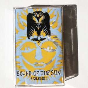 a light blue and yellow cassette tape on a white background. There is a black phoenix image overlaid on top of a cut-out "sun" face. text on cassette tape reads" SOUND OF THE SUN, VOLUME I